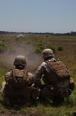 A Marine with Headquarters and Service Company, 2nd Maintenance Battalion, 2nd Marine Logistics Group fires a .50-caliber M2 machine gun down range under the guidance of a Marine with 2nd Battalion, 9th Marine Regiment, 2nd Marine Division during a field exercise aboard Camp Lejeune, N.C., May 9, 2013. Three machine gunners with 2nd Battalion, 9th Marines shared their expertise to aid the Marines from HqSvc. Co.