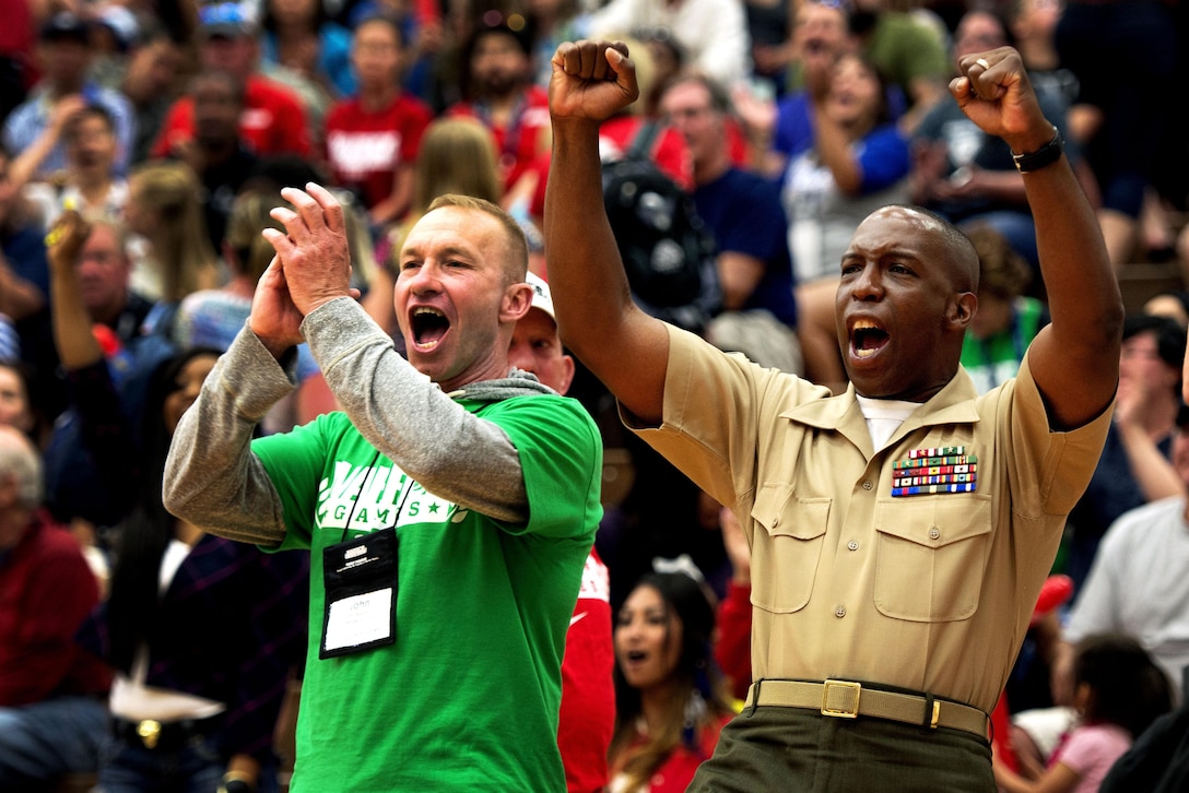 Sgt. Maj. Michael T. Mack, Wounded Warrior Regiment sergeant major, cheers for the Marine sitting basketball team during the first round of the sitting basketball tournament at the 2013 Warrior Games here May 12. From May 11-16, more than 200 wounded, ill and injured service members and veterans from the U.S. Marines, Army, Air Force and Navy, as well as a team representing U.S. Special Operations Command and an international team representing the United Kingdom, will compete for the gold in track and field, shooting, swimming, cycling, archery, wheelchair basketball and sitting volleyball at the U.S. Olympic Training Center and U.S. Air Force Academy here. The military service with the most medals will win the Chairman's Cup. 