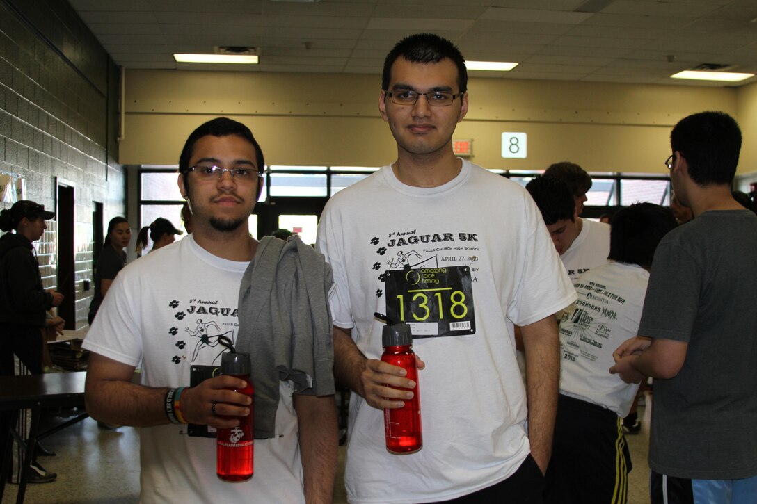 Ameer Khan and Isaiah Abadia hold up their brand new Marine Corps water bottles before the 8th annual Jaguar 5k at Falls Church High School April 27. The Marine Corps donated 900 water bottles to Falls Church High School to support the runners whose race entrance fees went to the athletic department.