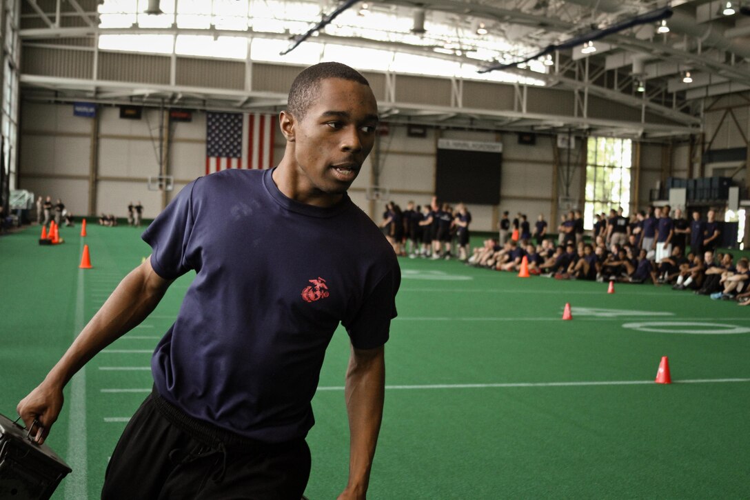 A poolee from Marine Corps Recruiting Station Baltimore runs with ammunition cans as part of a relay race during RS Baltimore's statewide pool function at the United States Naval Academy, May 11.