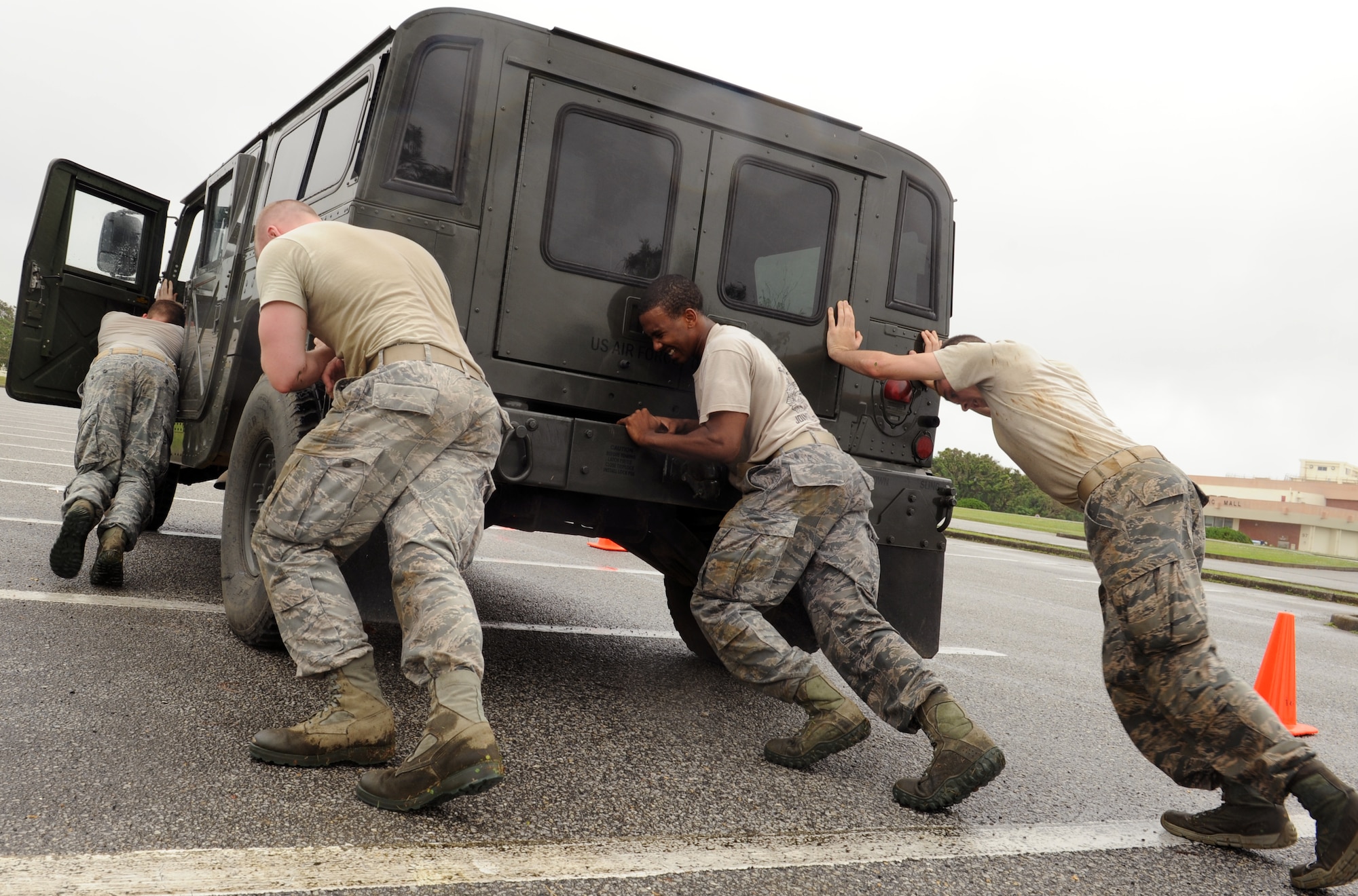 Members of the 18th Security Forces Squadron push a Humvee on Kadena Air Base, Japan, May 14, 2013. The participants were tasked with pushing the Humvee from cone to cone. This was one of several events that participants had to overcome during the 2013 Defenders Challenge varying from grenade tosses to weapon assembly. (U.S. Air Force photo by Airman 1st Class Keith A. James/Released)