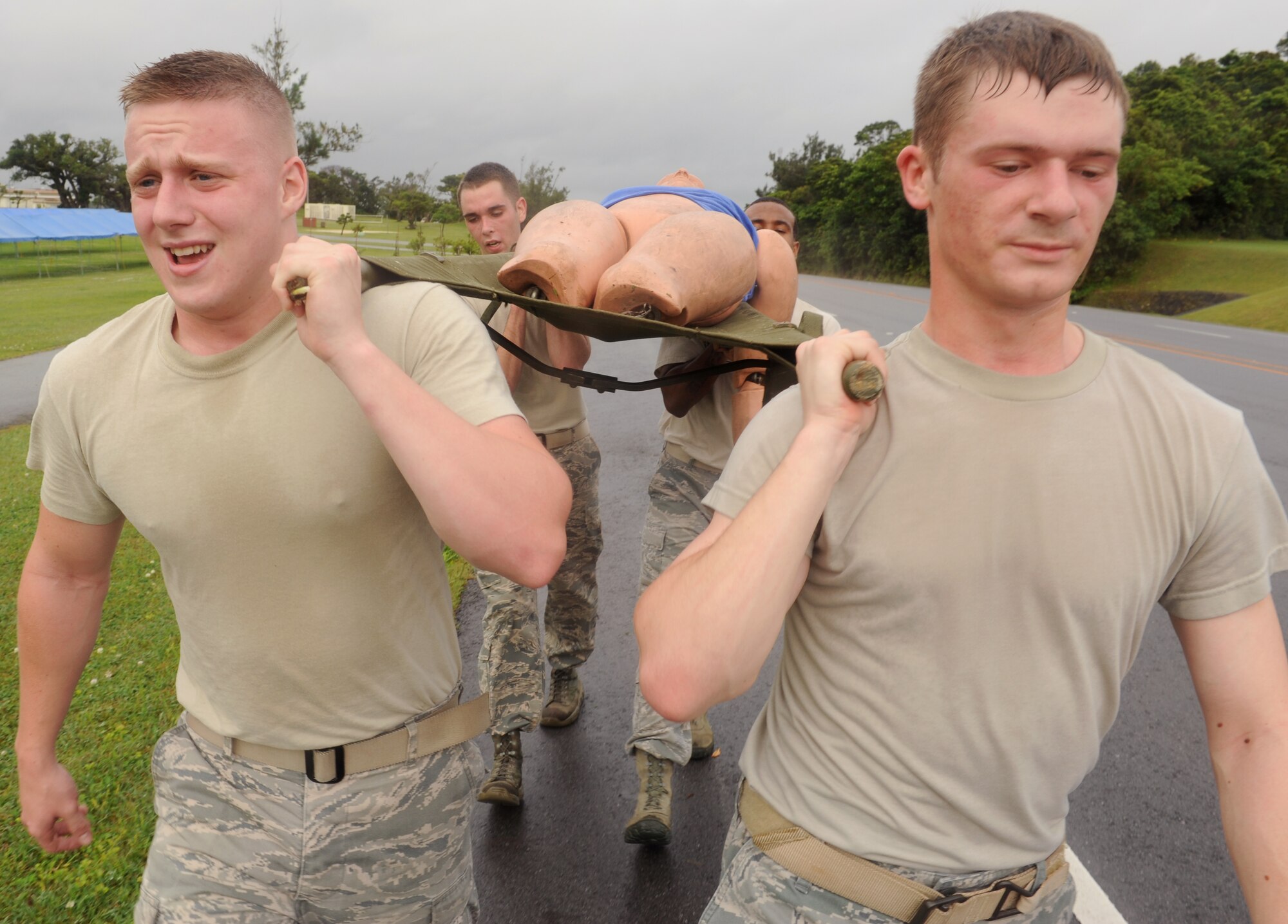 Members of the 18th Security Forces Squadron use a litter to transport a simulated injured person on Kadena Air Base, Japan, May 14, 2013. The members were instructed to carry the litter to a destination where injured personnel could receive medical treatment during the 2013 Defenders Challenge. (U.S. Air Force photo by Airman 1st Class Keith A. James/Released)