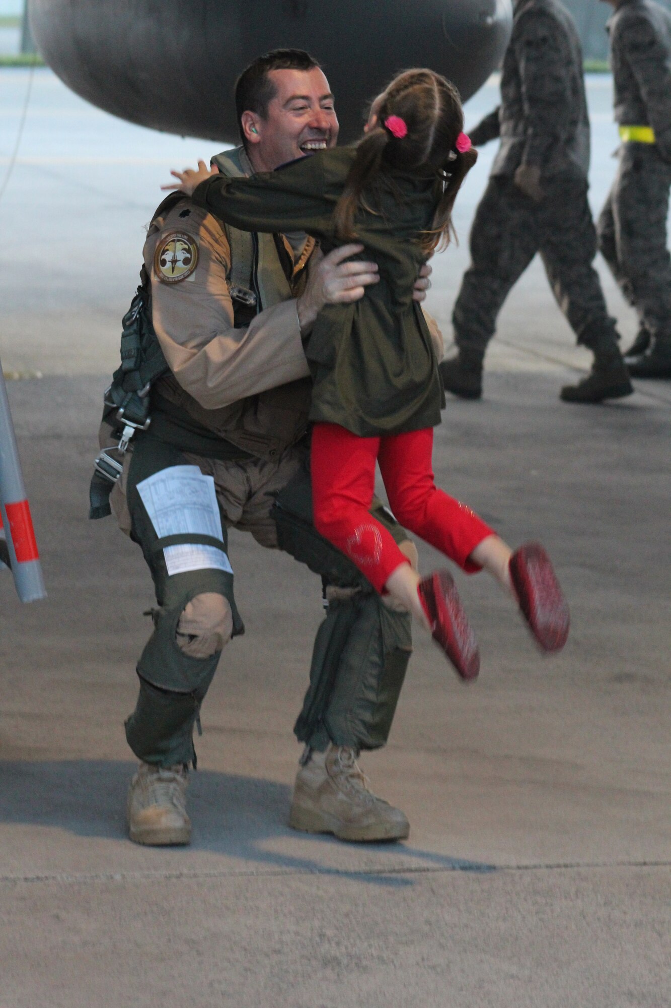 U.S. Air Force Lt. Col. John Holovich, 67th Fighter Squadron director of operations, gets a warm welcome from his daughter Reagan on Kadena Air Base, Japan, May 8, 2013. Members from the squadron were deployed for eight months. Family members and friends wore an article of red clothing during the event to show support and pride for the squadron. (U.S. Air Force photo by Lt. Col. John Jacobus/Released)
