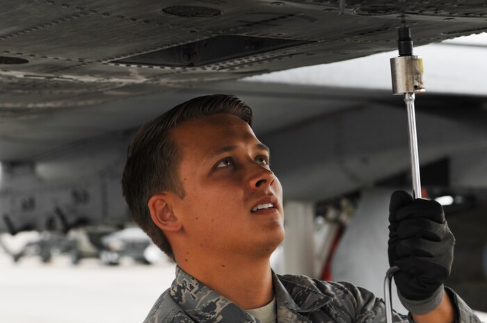 Airman 1st Class Adrian Sandoval, 757th Aircraft Maintenance Squadron, assistant dedicated crew chief, tightens bolts on the fuselage of an A-10 Thunderbolt II during a post flight inspection May 9, 2013, at Nellis Air Force Base, Nev. A post-flight inspection is performed after every sortie to inspect the aircraft for any damage and to correct any discrepancies that are found. (U.S. Air Force photo by Staff Sgt. Gregory Brook.) 