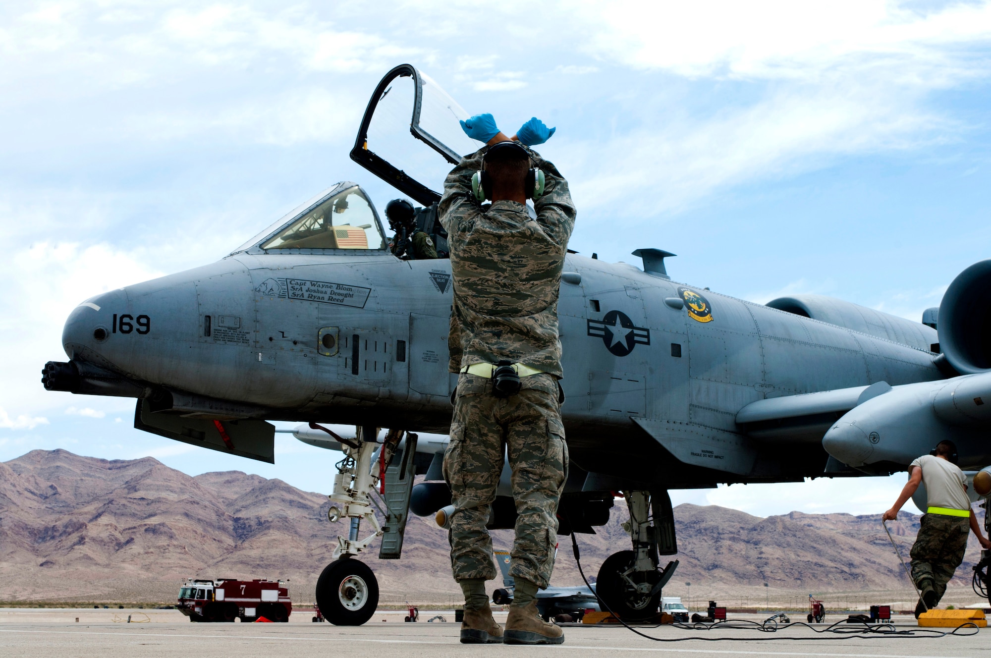 Airman Brandon Kempf, 757th Aircraft Maintenance Squadron assistant dedicated A-10 Thunderbolt II crew chief, communicates with a pilot using hand signals May 9, 2013, at Nellis Air Force Base, Nev. Crew chiefs use a wide variety of hand signals to direct pilots to the correct location in a loud flight line environment. (U.S. Air Force photo by Airman 1st Class Joshua Kleinholz)