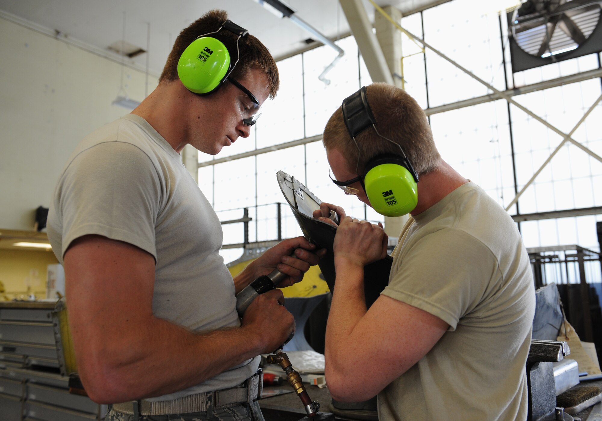 Staff Sgt. Cameron Elvin, 2nd Maintenance Squadron Fabrication Flight sheet metal, drills a rivet into a piece of equipment as Airman 1st Class John Nellist, 2nd MXS Fab Flight sheet metal, holds it in place on Barksdale Air Force Base, La., May 14, 2013. Airmen from the fabrication flight repair or replace sheet metal and fix loose rivets and cracks on the B-52H Stratofortress. (U.S. Air Force photo/Airman 1st Class Benjamin Gonsier)
