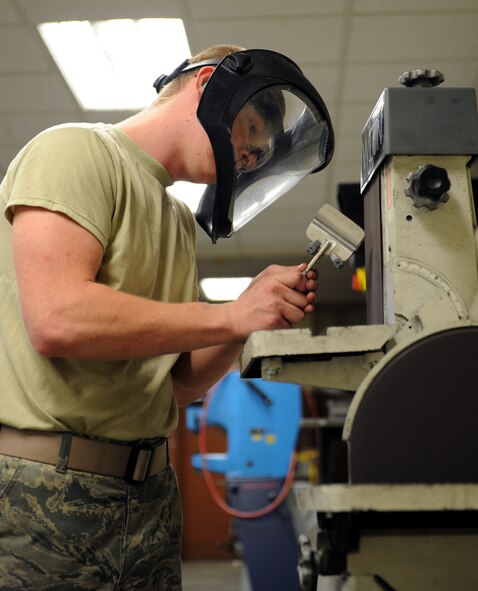 Airman 1st Class John Nellist, 2nd Maintenance Squadron Fabrication Flight sheet metal, rounds off the edges to a door hinge on Barksdale Air Force Base, La., May 14, 2013. Sheet metal Airmen create metal parts for aircraft and other equipment when parts need to be replaced. (U.S. Air Force photo/Airman 1st Class Benjamin Gonsier)