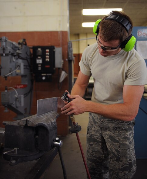 Staff Sgt. Cameron Hayden, 2nd Maintenance Squadron Fabrication Flight sheet metal, rounds off the edges to a piece of sheet metal on Barksdale Air Force Base, La., May 14, 2013. Sheet metal Airmen create metal parts for aircraft and other equipment when parts need to be replaced. (U.S. Air Force photo/Airman 1st Class Benjamin Gonsier)