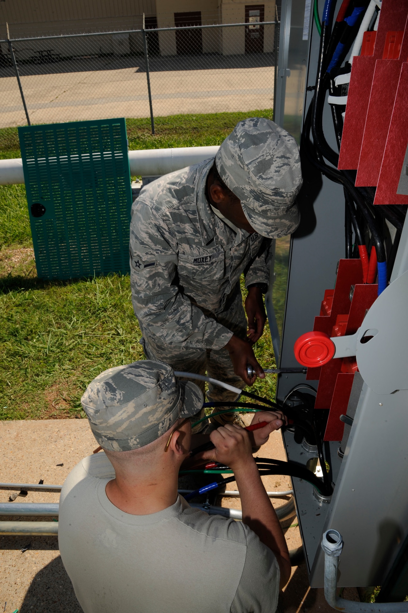 Airman 1st Class Zane Johnson, foreground, and Airman Rahim Moxley, 2nd Civil Engineer Squadron Electrical Power Production, attach cabling to a fuse box during the installation of a generator on Barksdale Air Force Base, La., May 14, 2013. Power production's responsibilities include maintaining backup generators and power facilities throughout Barksdale. (U.S. Air Force photo/Airman 1st Class Andrew Moua)