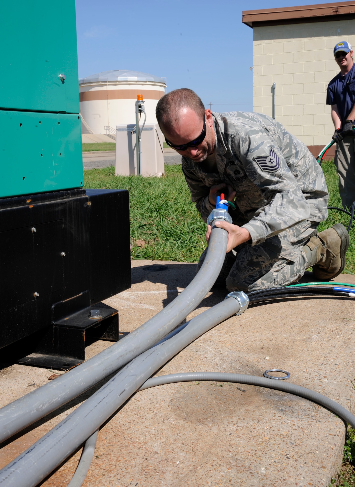 Tech. Sgt. Christopher Collins, 2nd Civil Engineer Squadron Electrical Power Production, feeds cabling through a pipe during the installation of a generator on Barksdale Air Force Base, La., May 14, 2013. Power production's responsibilities include maintaining backup generators and power facilities throughout Barksdale. (U.S. Air Force photo/Airman 1st Class Andrew Moua)