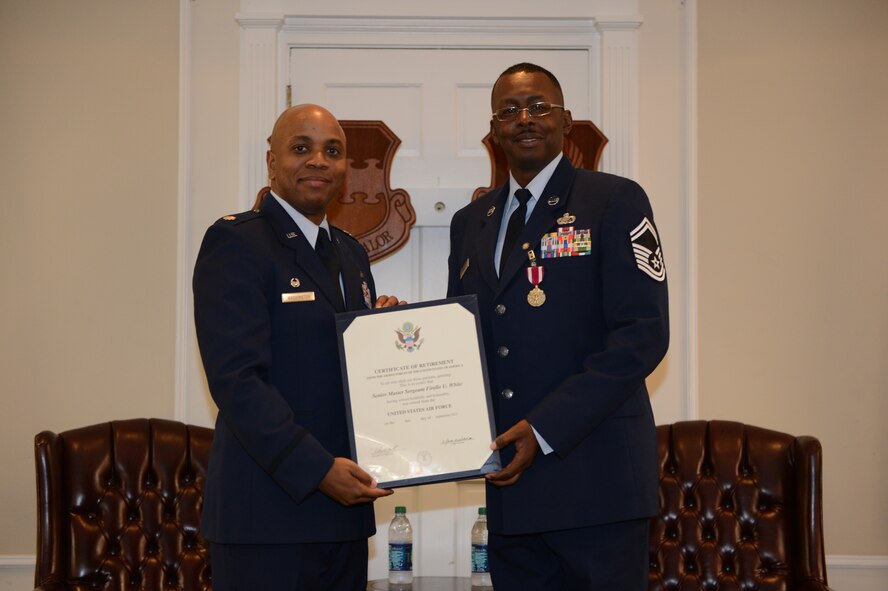 Lt. Col. Dalian Washington, 20th Force Support Squadron commander, presents Senior Master Sgt. Firello White, 20th FSS Sustainment Flight superintendent, with his certificate of retirement at Shaw Air Force Base, S.C., May 8, 2013. White will officially retire Sept. 1, 2013, after 25 years of service. (U.S. Air Force photo by Airman 1st Class Krystal M. Jeffers/Released)