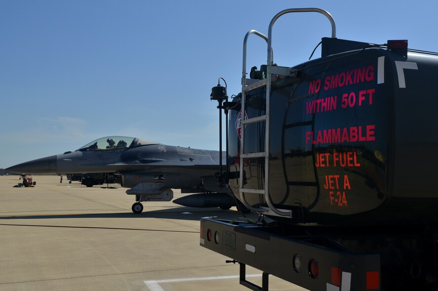 A fuel truck is parked beside an F-16 Fighting Falcon prior to refueling the jet during a hot pits refueling, Shaw Air Force Base, S.C., May 9, 2013. The hot pits refueling process is practiced to prepare for fast-tempo refueling and to make sure pilots are able to take flight as soon as possible. (U.S. Air Force photo by Airman 1st Class Ashley L. Gardner/Released)