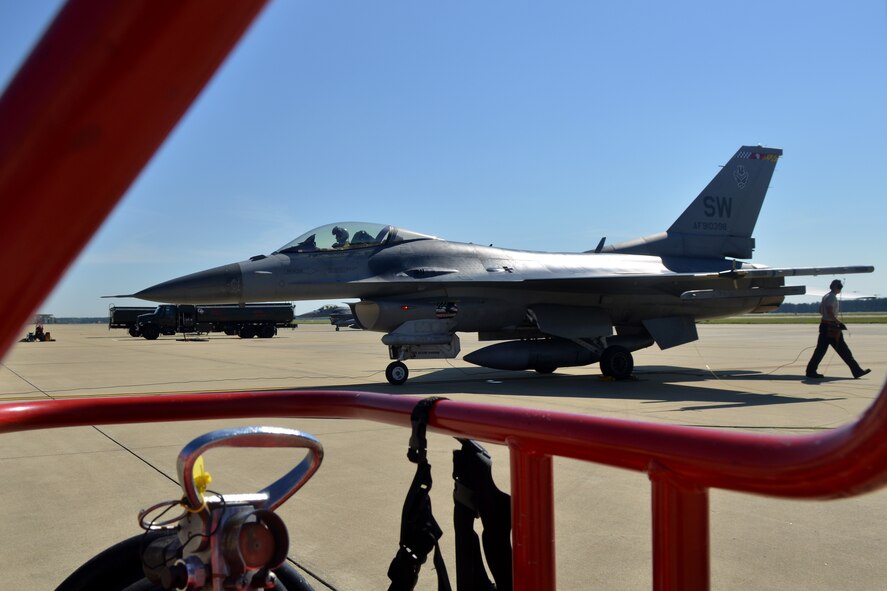 An F-16 Fighting Falcon runs hot as it prepares to go back up in the air after a hot pits refueling, Shaw Air Force Base, S.C., May 9, 2013. The hot pits refueling process is practiced in order to prepare for fast-tempo refueling and to make sure pilots are able to take flight as soon as possible. (U.S. Air Force photo by Airman 1st Class Ashley L. Gardner/Released)