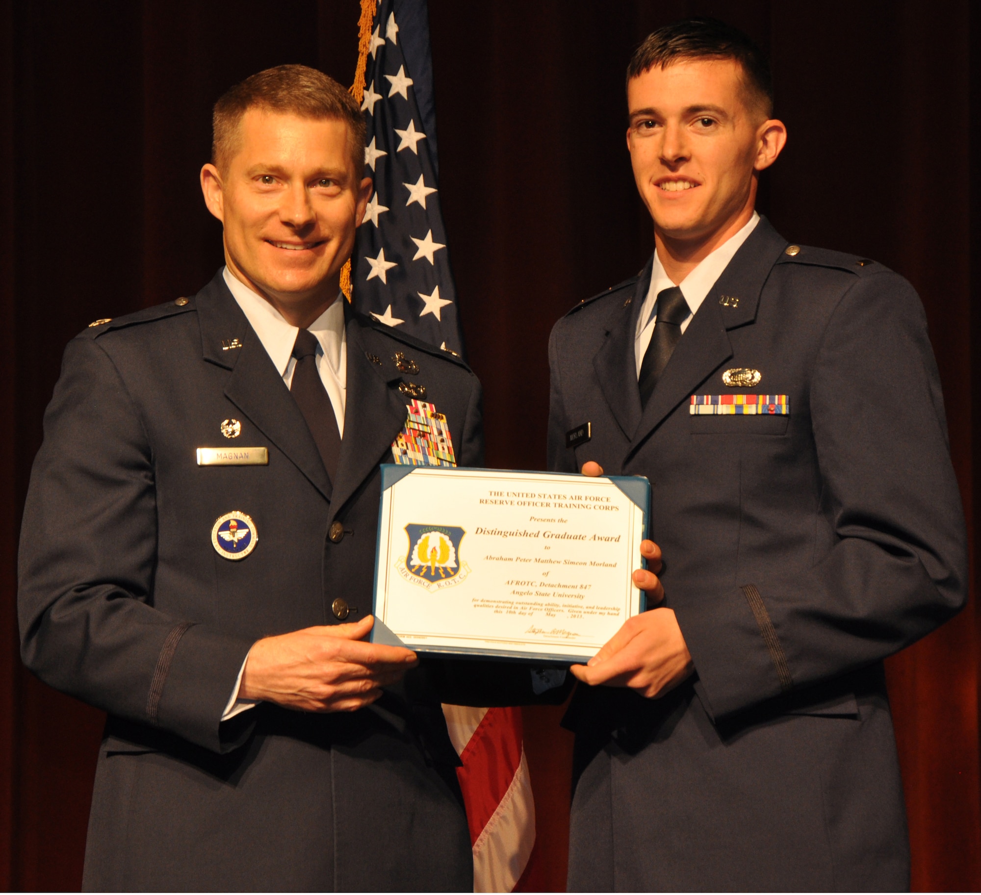 SAN ANGELO, Texas - Lt. Col. Stephen Magnan, Angelo State University Air Force ROTC Detachment 847 Commander, presents 2nd Lt. Abraham Morland, former AFROTC Det 847 cadet, the Distinguished Graduate award during a ROTC commissioning ceremony at the ASU Houston Harte University Center here, May 10.  Morland is scheduled to attend pilot training. (U.S. Air Force photo/ Airman 1st Class Joshua Edwards)