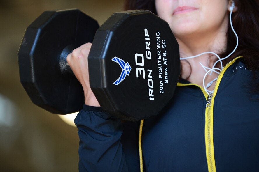 Rachell Davis, retired U.S. Air Force weather meteorologist, National Physique Committee bikini competitor and power lifter and lifestyle coach curls a dumbbell the Fitness Center, Shaw Air Force Base, S.C., May 13, 2013.  Davis has competed three times in the past two years in physique competitions and three times in power lifting competitions. (U.S. Air Force photo by Airman 1st Class Nicole Sikorski/Released)