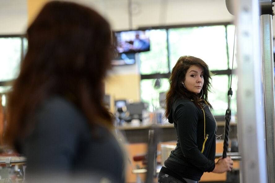 Rachell Davis, retired U.S. Air Force weather meteorologist, National Physique Committee bikini competitor and power lifter and lifestyle coach looks in the mirror while doing tricep press-downs at the Fitness Center, Shaw Air Force Base, S.C., May 13, 2013.  Davis has competed three times in the past two years in physique competitions and three times in power lifting competitions. (U.S. Air Force photo by Airman 1st Class Nicole Sikorski/Released)
