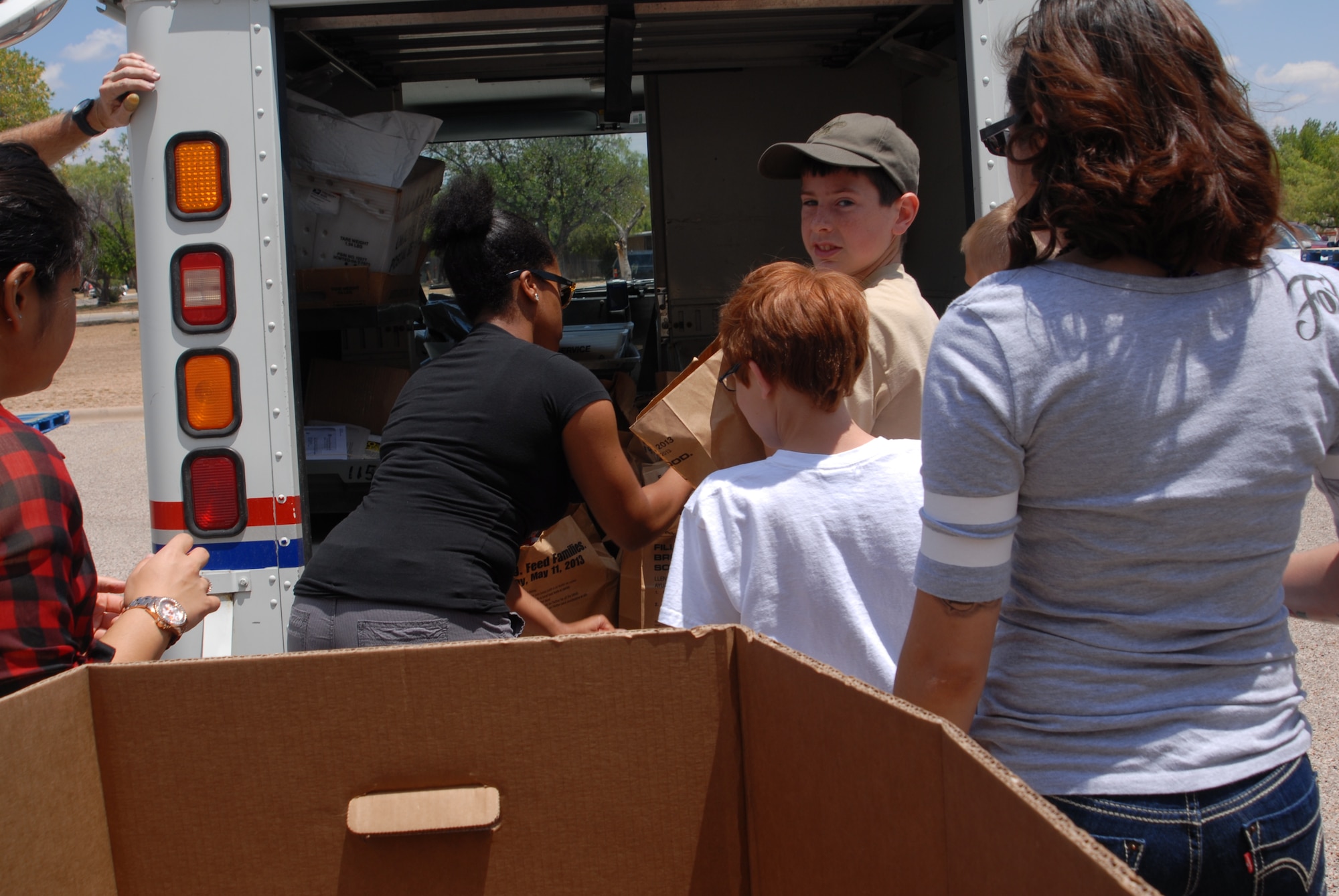 SAN ANGELO, Texas – Volunteers move sacks and bags of canned goods and food products from the back of the postal truck at the Concho Valley Regional Food Bank, May 11. The Concho Valley Regional Food bank worked with the National Association of Letter Carriers Food Drive to collect non-perishable food items.  (U.S. Air Force photo/ Airman 1st Class Breonna Fields)

