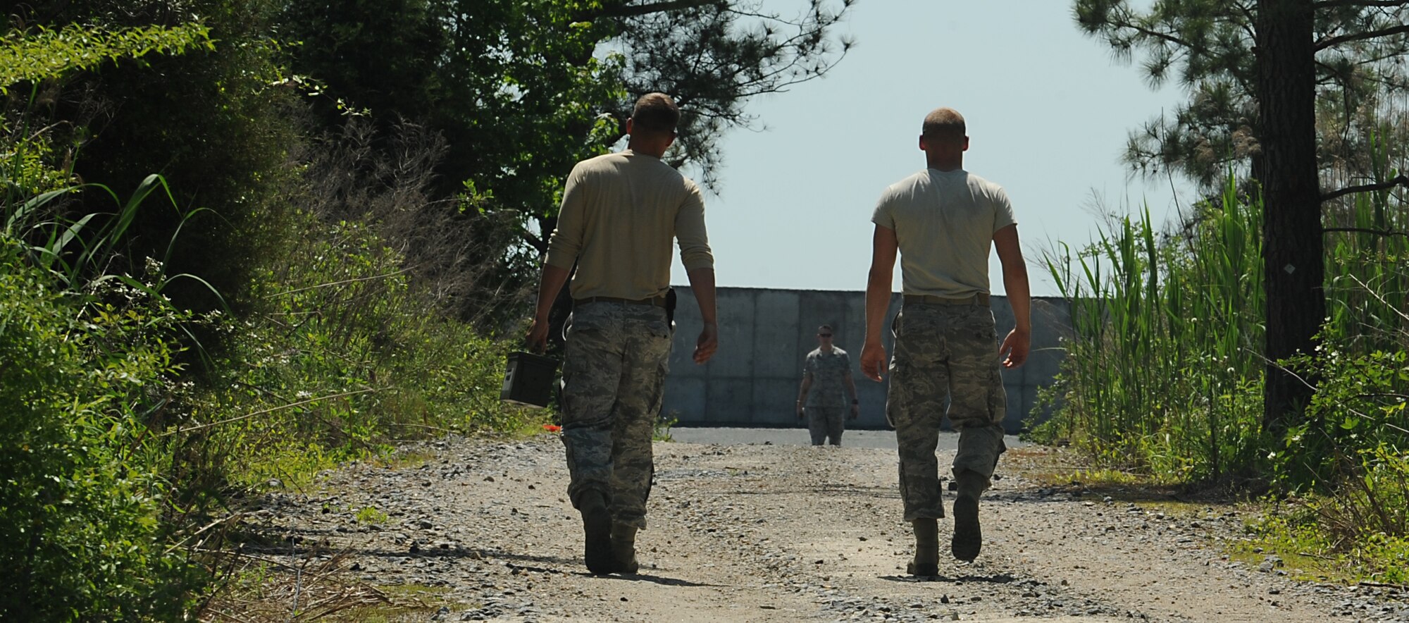 Airmen of the 633rd Civil Engineer Squadron explosive ordnance disposal walk towards the EOD range on Langley Air Force Base Va., May 10, 2013. The Airmen were investigating the range after a controlled explosion. (U.S Air Force photo by Airman 1st Class Kimberly Nagle/Released)
