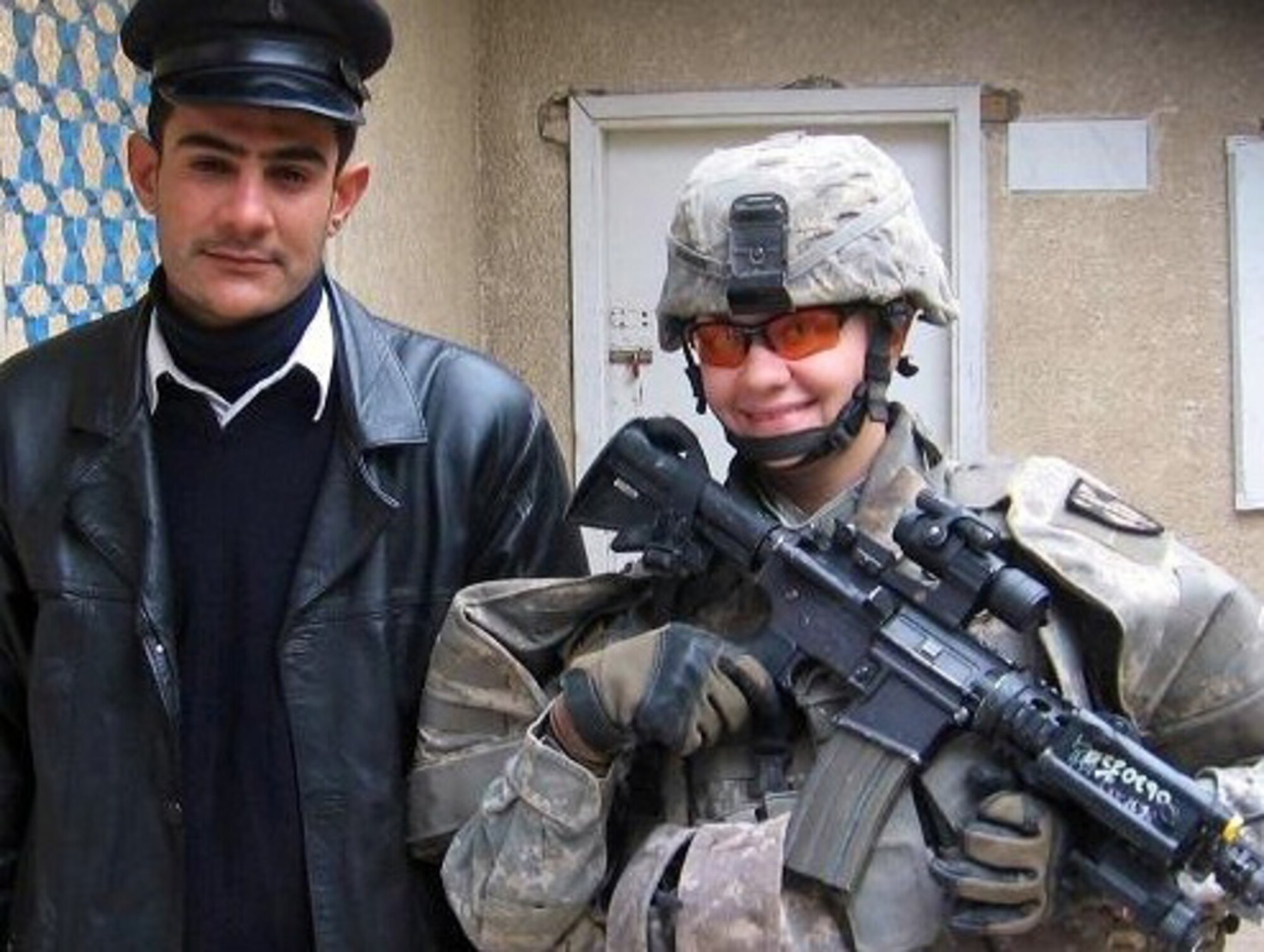 (Retired) Sgt. Jolene Raciborski takes a photo with an Iraqi police officer during her deployment. (Courtesy Photo)
