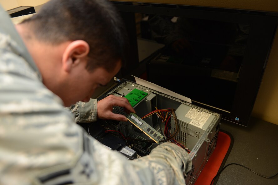Airman 1st Class Justin Pence, 20th Communications Squadron client service technician, works to fix a computer submitted to the squadron at Shaw Air Force Base, S.C., May 8, 2013. Fixing and facilitating the repair of base computers is one of the 20th CS’s many responsibilities. (U.S. Air Force photo by Airman 1st Class Daniel Blackwell/Released)