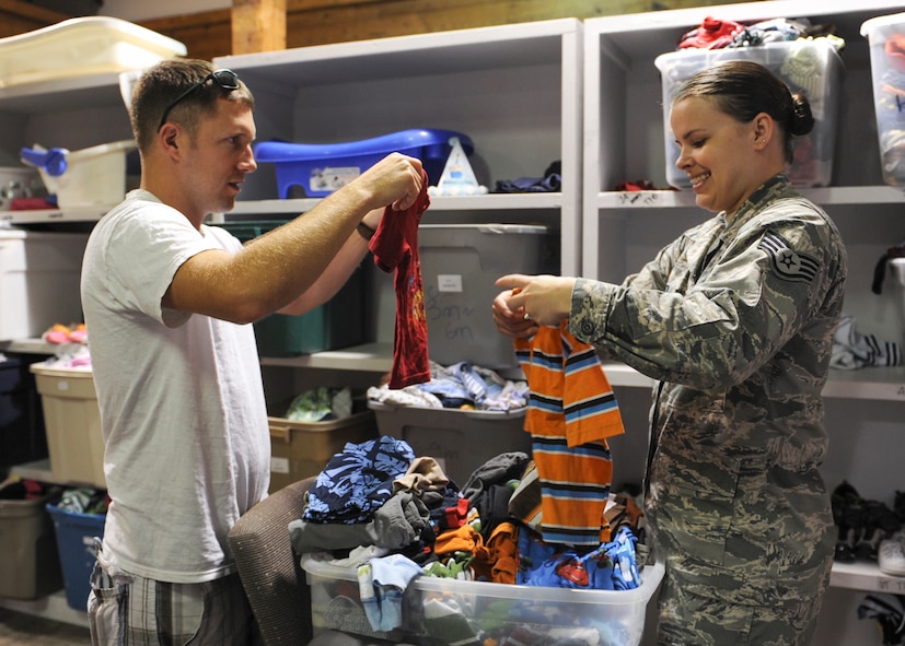 U.S. Air Force Tech. Sgt. Chris Lauer, 23d Maintenance Group quality inspector, and his wife Staff Sgt. Jaime Lauer, 23d Equipment Maintenance Squadron commander support staff, look through bins of donated baby clothes in the Airman’s Attic at Moody Air Force Base, Ga., May 7, 2013. The couple volunteers, as well as utilizes the Airman’s Attic program that offers donated uniforms and household goods at no cost to Airmen E-5 and below. (U.S. Air Force photo by Senior Airman Eileen Meier/Released)