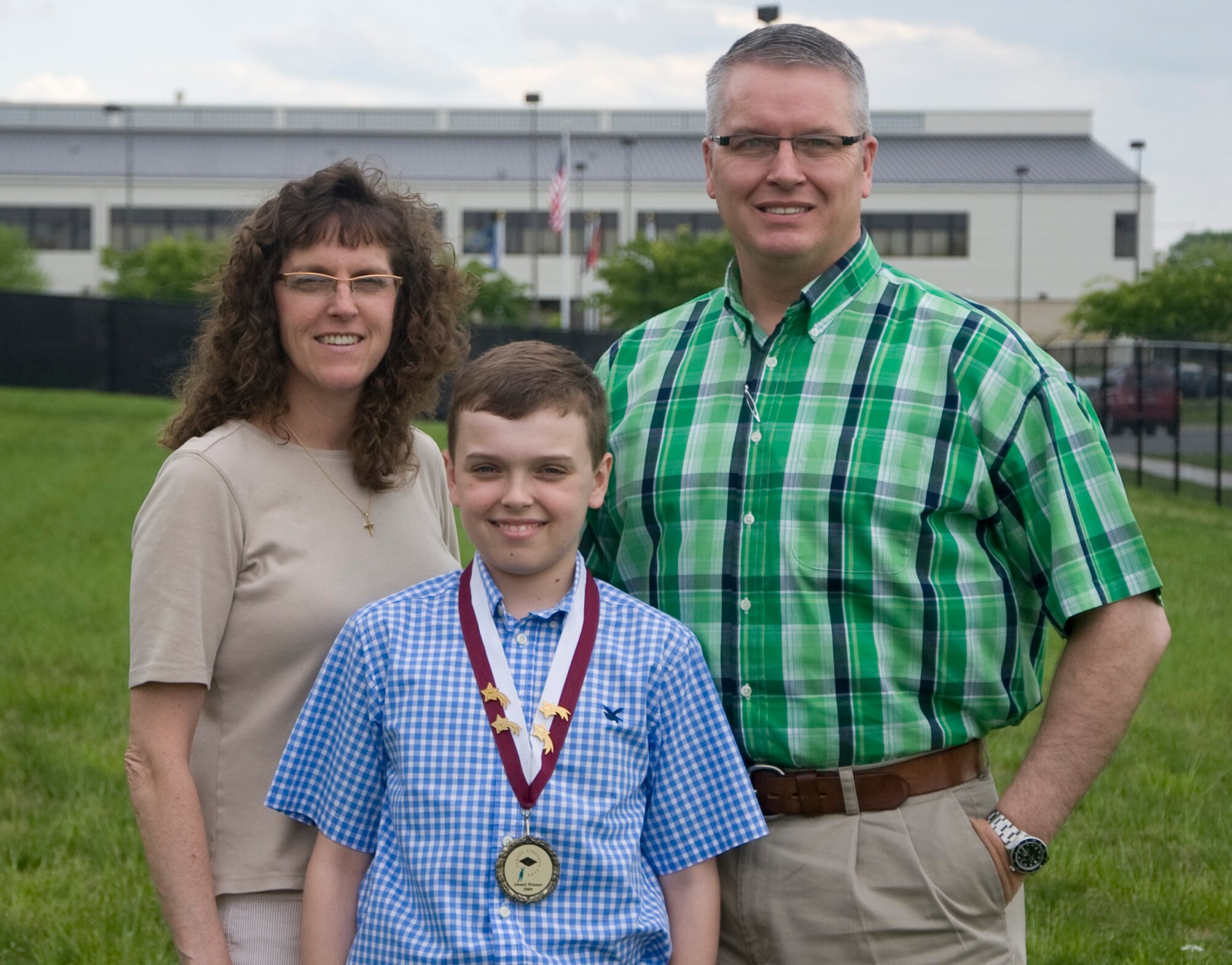 Alden Tonkay, five-time winner of the Carson Scholarship, poses with his parents Jack Tonkay, Joint Personal Effects Depot information technology specialist, and Laurie Tonkay, Welch Elementary School third-grade school teacher, May 10, 2013, Dover Air Force, Del. Carson Scholarships are awarded to students in grades 4-11 who exemplify academic excellence and humanitarian qualities..)