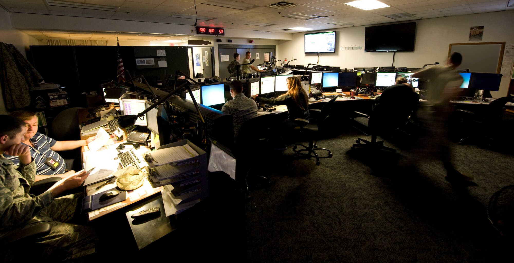 Air Terminal Operations Center and Maintenance Operations Control Center personnel inside the command post May 13, 2013, at the command post on Dover Air Force Base, Del. The command post is the focal point of all information concerning Dover. (U.S. Air Force illustrator/Senior Airman Jared Duhon.)