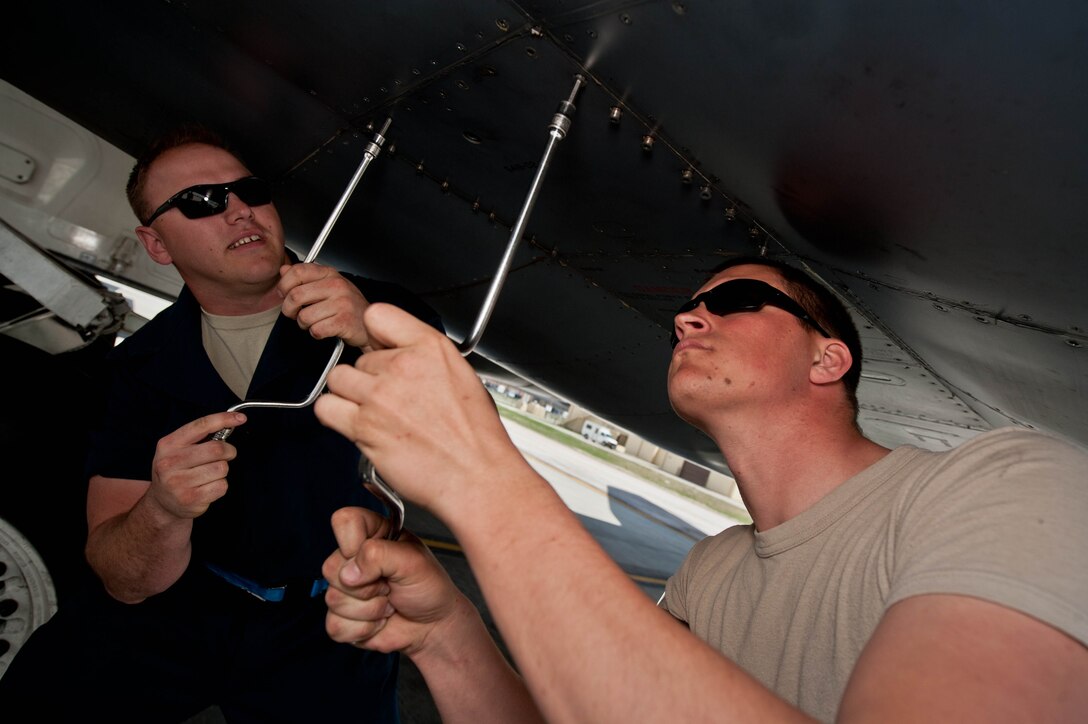 Staff Sgt. Bryce Woodall, and Airman 1st Class Jeremiah Palmer, 28th Aircraft Maintenance Squadron hydraulic technicians, open a panel on a B-1 bomber to install a pre-cooler blower at Ellsworth Air Force Base, S.D., May 8, 2013. Aircraft hydraulic system specialists have knowledge of hydraulic, pneumatic, electrical and mechanical principles applicable to aircraft and support equipment and hydraulic systems. (U.S. Air Force photo by Airman 1st Class Zachary Hada/Released)