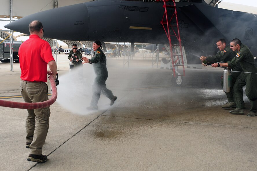 U.S. Air Force Lt. Col. Nicole Malachowski, 333rd Fighter Squadron commander, is hosed down by her spouse, retired Lt. Col. Paul Malachowski, and Airmen from the 333rd FS on Seymour Johnson Air Force Base, N.C., May 8, 2013. It is traditional for an aircrew member to be hosed down by someone close to them after conducting their final flight. (U.S. Air Force photo by Airman 1st Class John Nieves Camacho/Released)