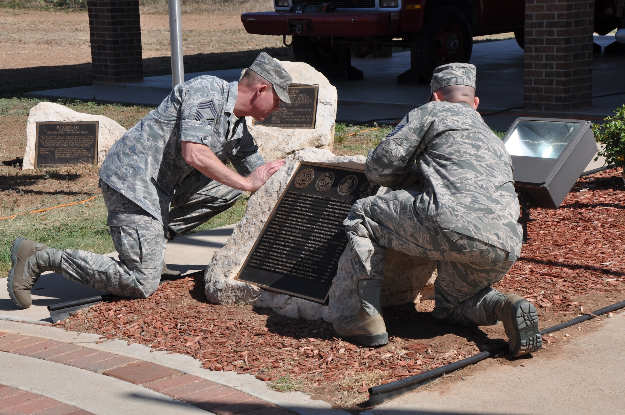 GOODFELLOW AIR FORCE BASE, Texas – Chief Master Sgt. Albert Sisco, 312th Training Squadron superintendent, and Master Sgt. Stephen Thompson, 312th TRS instructor, unveil the fallen Defense Department firefighters’ names at a firefighter memorial here, May 3. This year, Goodfellow added seven new names to this memorial rock. (U.S. Air Force photo/ Airman 1st Class Joshua Edwards)
