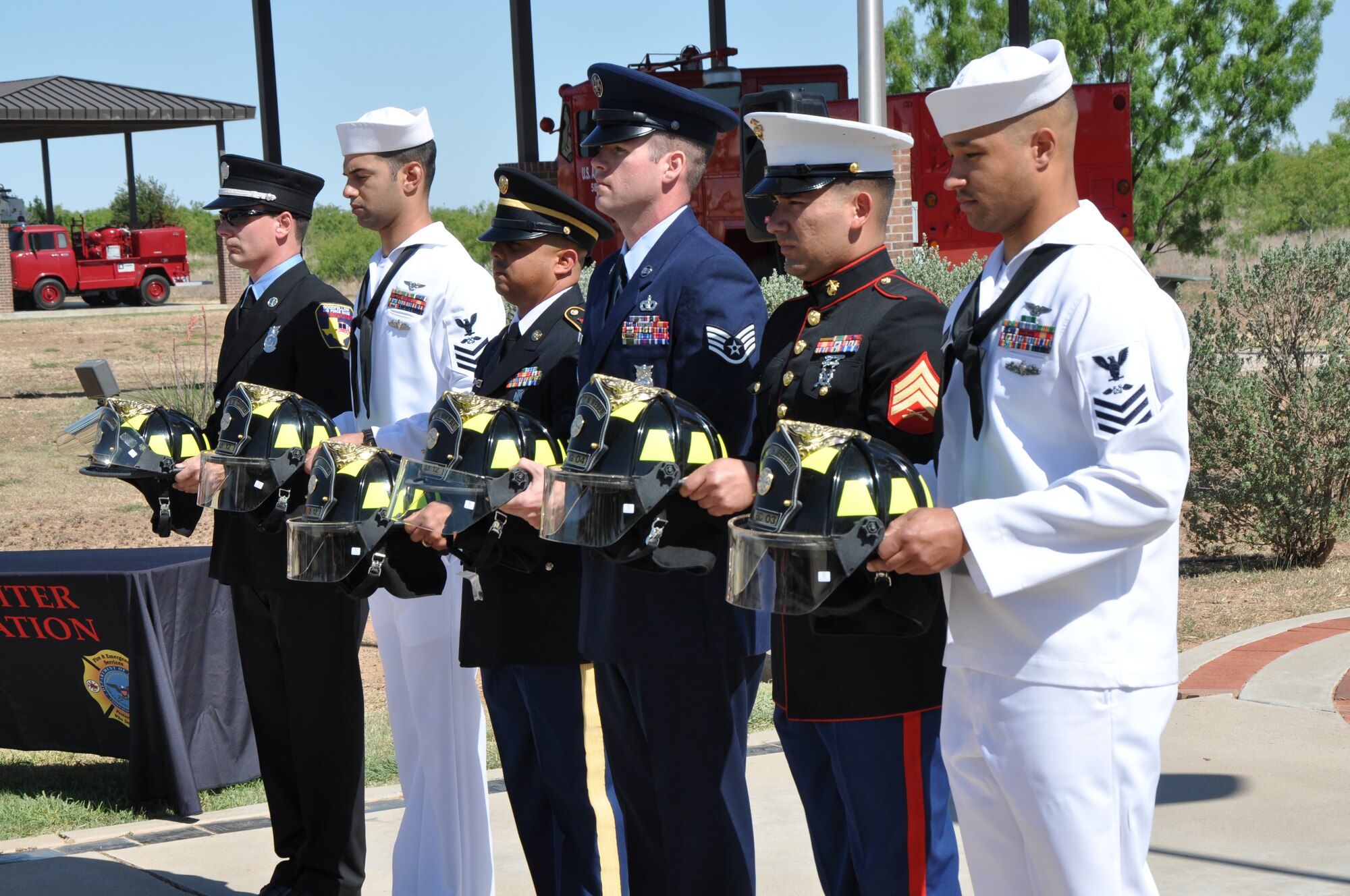 GOODFELLOW AIR FORCE BASE, Texas - The Base Joint Service Color Guard hold fallen Defense Department firefighters’ helmets at a firefighter memorial here, May 3. Family members of Assistant Chief Kenneth Jeffery, Naval Submarine Base New London, and Marine Cpl. Robert Weber, Jr., Marine Corps Air Station Beaufort, received their fallen family member’s helmets at the event. (U.S. Air Force photo/ Airman 1st Class Joshua Edwards)