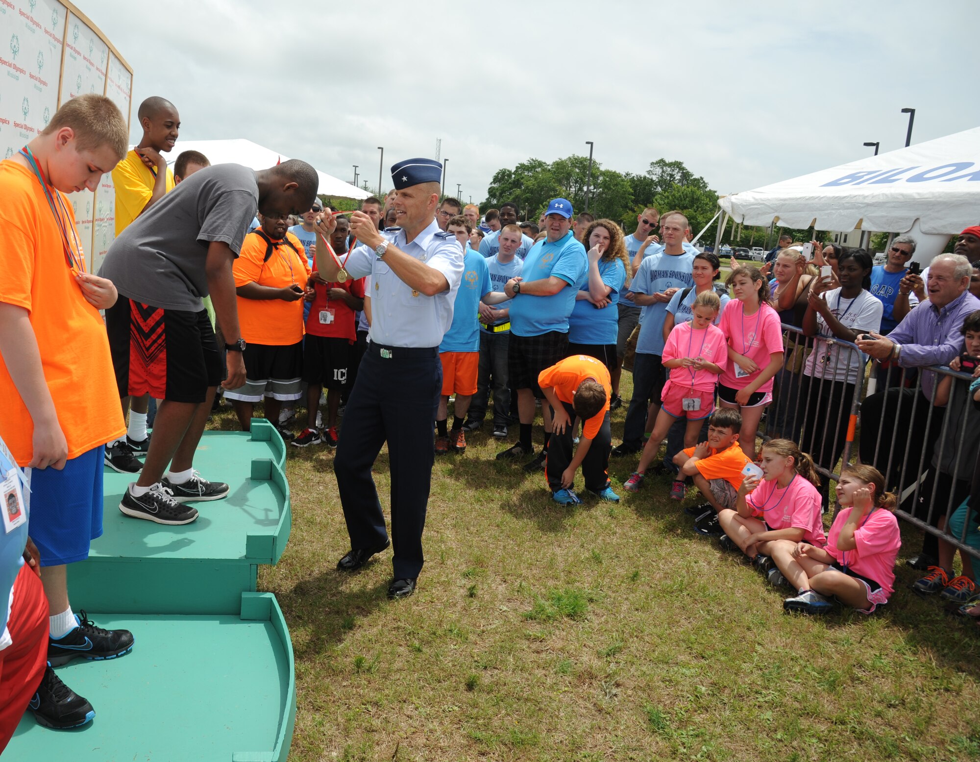 Brig. Gen. Brad Spacy, 81st Training Wing commander, presents a gold medal to Kenny, athlete, at the Special Olympics Mississippi Summer Games on May 11, 2013, at Keesler Air Force Base, Miss.  More than 900 athletes and 3,000 volunteers worked together to hold competitions throughout the day.  This is the 27th year Keesler has hosted the state Special Olympics.   (U.S. Air Force photo by Kemberly Groue)