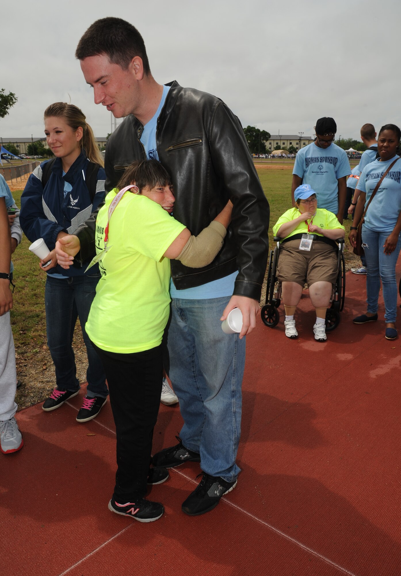 Vicky Randolph, athlete, hugs her sponsor, Airman 1st Class George Woodard, 334th Training Squadron, after she completed the 25-meter assisted walk at the Special Olympics Mississippi Summer Games on May 11, 2013, at Keesler Air Force Base, Miss.  More than 900 athletes and 3,000 volunteers worked together to hold competitions throughout the day.  This is the 27th year Keesler has hosted the state Special Olympics.   (U.S. Air Force photo by Kemberly Groue)