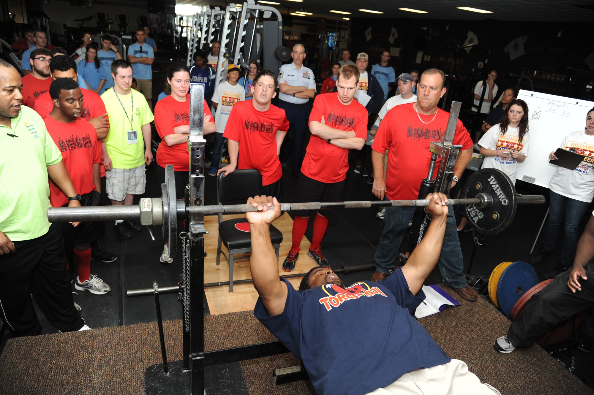 Ricardo Clayton, volunteer, demonstrates to athletes the proper and safe way to bench press at the Special Olympics Mississippi Summer Games on May 11, 2013, at the Triangle Fitness Center, Keesler Air Force Base, Miss.  More than 900 athletes and 3,000 volunteers worked together to hold competitions throughout the day.  This is the 27th year Keesler has hosted the state Special Olympics.   (U.S. Air Force photo by Kemberly Groue)