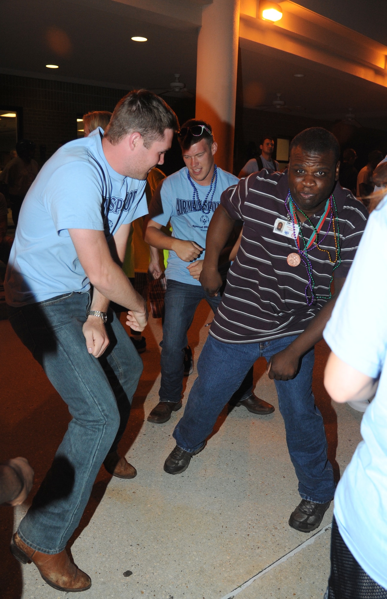 Airmen Basic Zach Sheene and Kendall Davis, 335th Training Squadron, dance with Alavino Jones, athlete, at closing ceremonies during the Special Olympics Mississippi Summer Games on May 11, 2013, at the Triangle Fitness Center, Keesler Air Force Base, Miss.  More than 900 athletes and 3,000 volunteers worked together to hold competitions throughout the day.  This is the 27th year Keesler has hosted the state Special Olympics.   (U.S. Air Force photo by Kemberly Groue)  