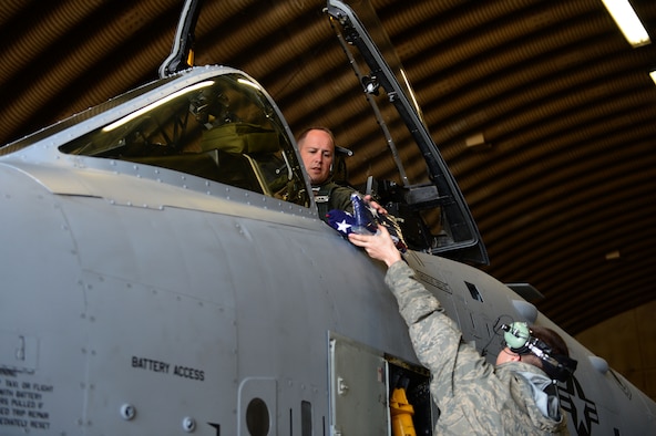 SPANGDAHLEM AIR BASE, Germany – U.S. Air Force Lt. Col. Jeffrey Hogan, 81st Fighter Squadron director of operations from Olympia, Wash., receives an American flag from Senior Airman Christopher Nichols, 52nd Aircraft Maintenance Squadron specialist May 14, 2013. This tactical sortie is scheduled to be the last before the squadron’s inactivation in June. (U.S. Air Force photo by Tech. Sgt. Jonathan Pomeroy/Released)