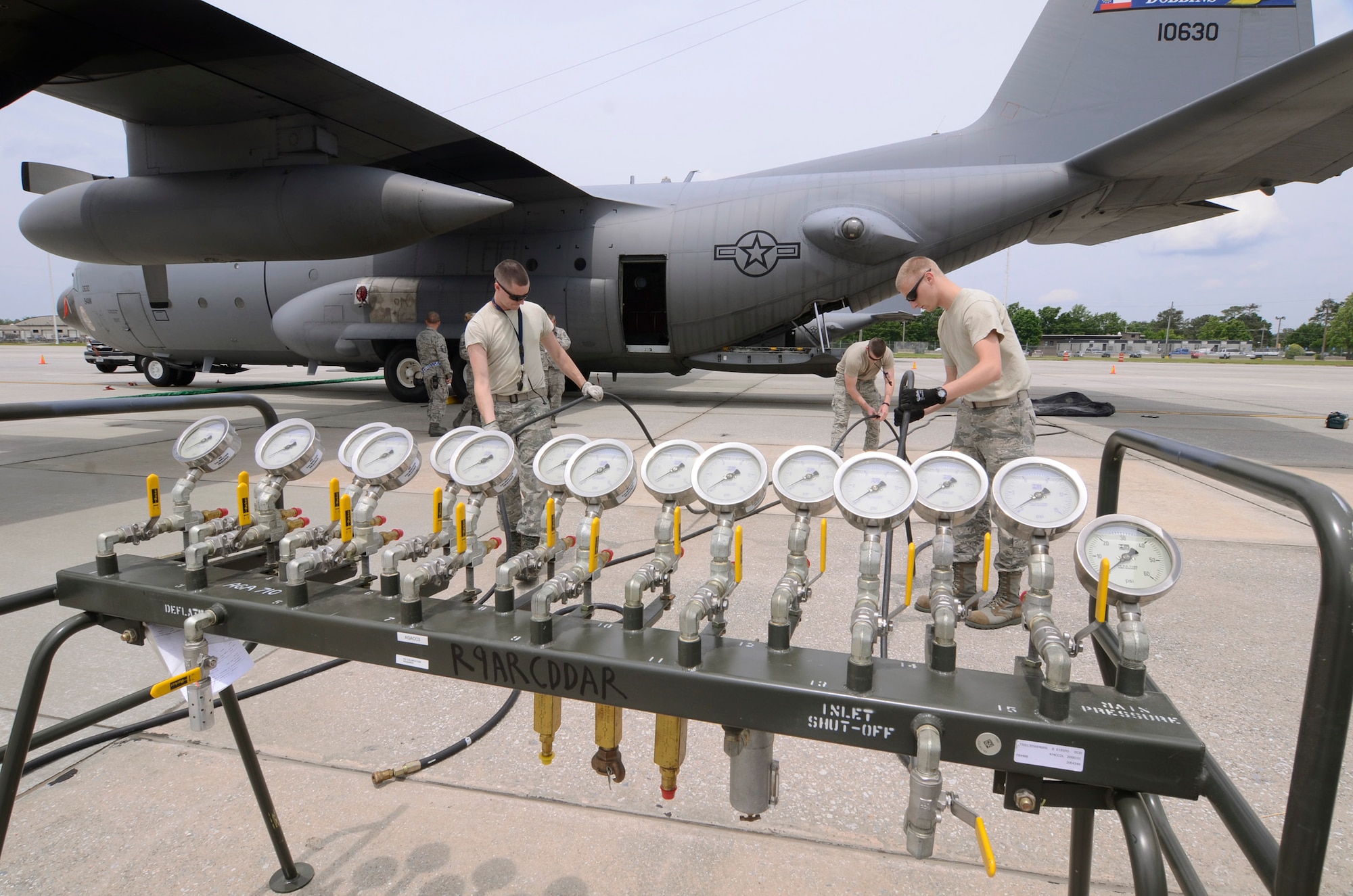 Members of the Crash, Damaged, and Disabled Aircraft Recovery (CDDAR) Team from the 94th Maintenance Squadron assemble a distribution console to fill large 15 ton capacity lifting bags to prevent damage to the underside of the aircraft when lifting the nose portion.  For the purpose of the exercise, filling the bags was simulated. The team was deployed in response to an exercise scenario of a refueling truck colliding with a C-130 Hercules on the Dobbins Air Reserve Base ramp May 10. The exercise was part of a Consolidated Unit Inspection (CUI) conducted on Dobbins. (U.S. Air Force photo/Don Peek)