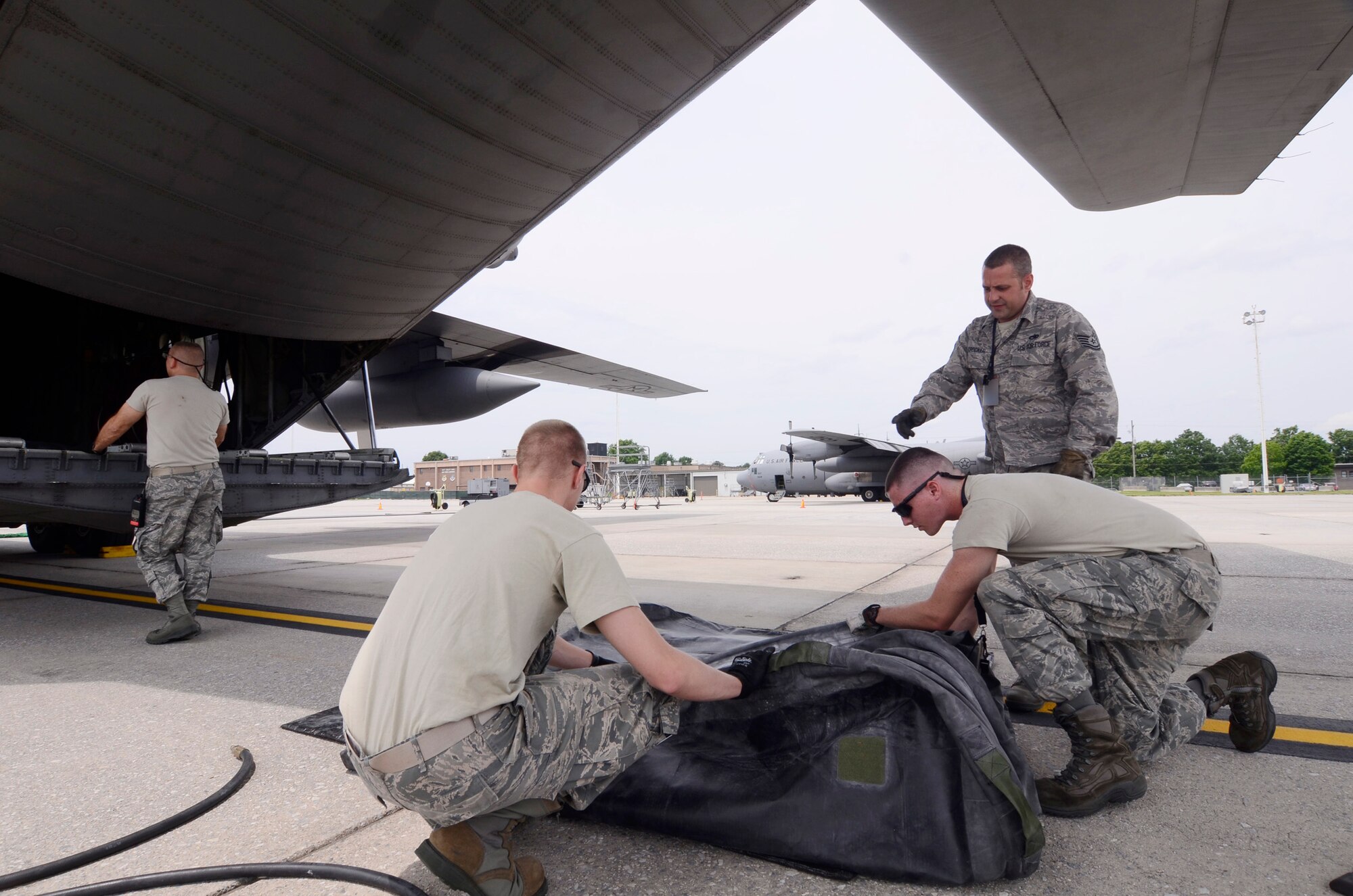 Members of the Crash, Damaged, and Disabled Aircraft Recovery (CDDAR) Team from the 94th Maintenance Squadron install 15 ton capacity lifting bags to prevent damage to the underside of the aircraft when lifting the nose portion.  For the purpose of the exercise, filling the bags was simulated. The team was deployed in response to an exercise scenario of a refueling truck colliding with a C-130 Hercules on the Dobbins Air Reserve Base ramp May 10. The exercise was part of a Consolidated Unit Inspection (CUI) conducted on Dobbins. (U.S. Air Force photo/Don Peek)
