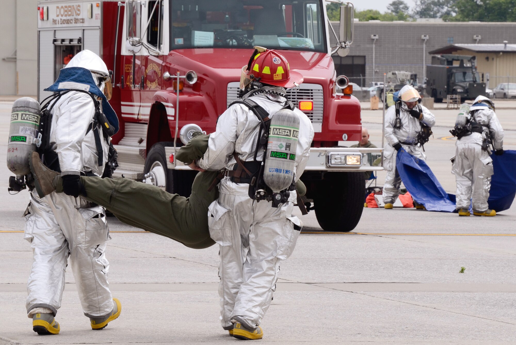 Member of the Dobbins Fire Department evacuates and assists simulated injured crew members while responding to a realistic scenario involving the collision of an aircraft refueling truck and a C-130 Hercules during an exercise held on Dobbins Air Reserve Base, Ga. May 10. (U.S. Air Force photo/Don Peek)