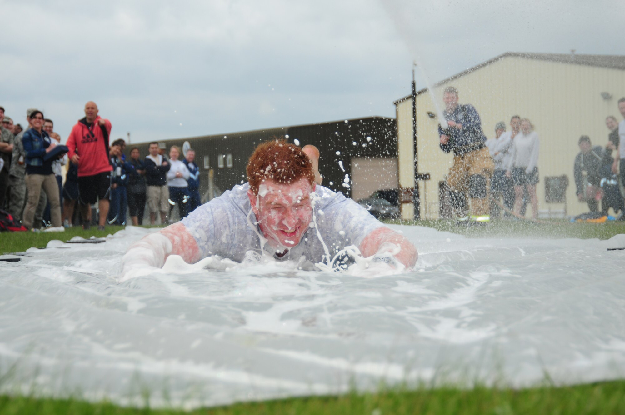 Staff Sgt. Jonathon Williams, 100th Security Forces Squadron trainer, gets a face-full of foam as he glides along the “slip-n-slide” May 10, 2013, at a post Unit Effectiveness Inspection celebration on RAF Mildenhall, England. Airmen had the opportunity to relax and compete against other squadrons in morale-boosting sports challenges after a Unit Effectiveness Inspection. (U.S. Air Force photo by Karen Abeyasekere/Released)