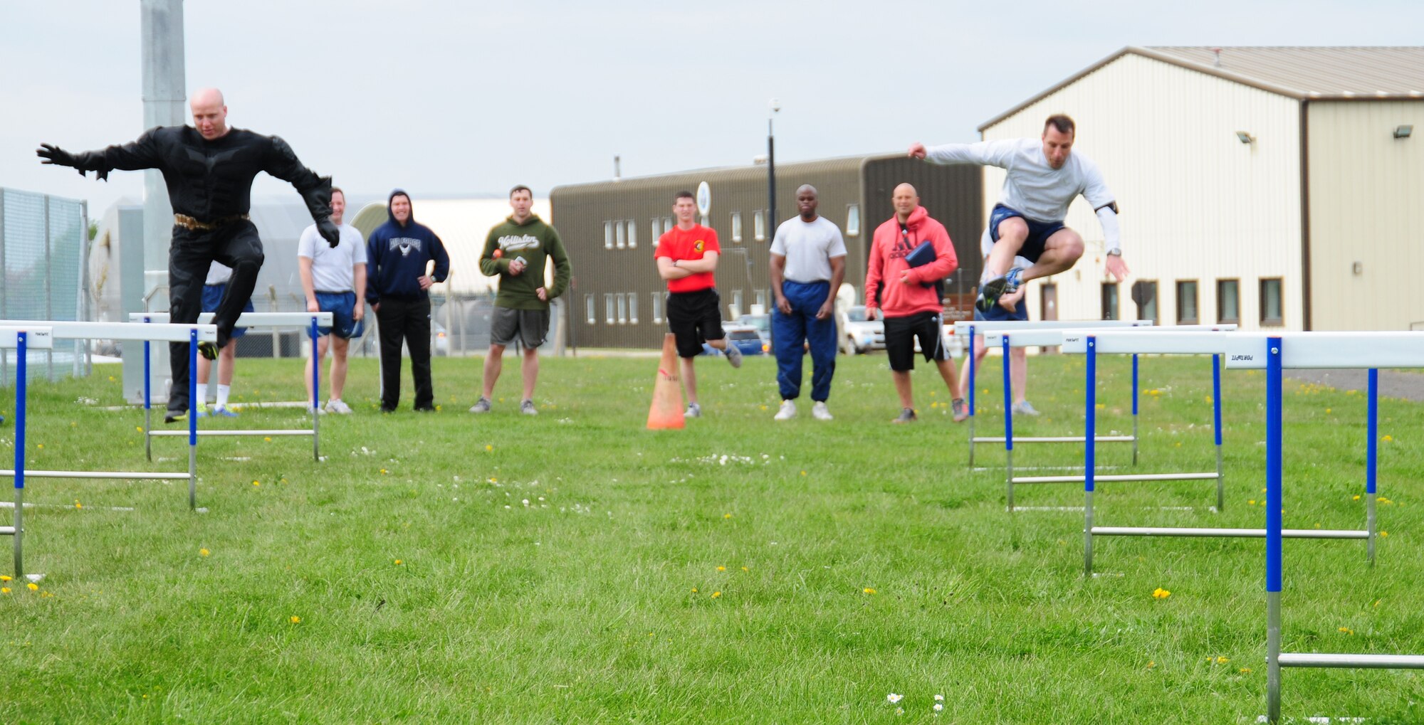 From left, “Batman,” (Master Sgt. Thomas Wagner, 100th Maintenance Squadron first sergeant) takes on Col. Christopher Kulas,  100th Air Refueling Wing commander, in the hurdles race May 10, 2013, at a post Unit Effectiveness Inspection celebration on RAF Mildenhall, England. Team Mildenhall members took part in a formation run along the taxiway and perimeter road, before enjoying a barbecue and sports challenges. (U.S. Air Force photo by Karen Abeyasekere/Released)