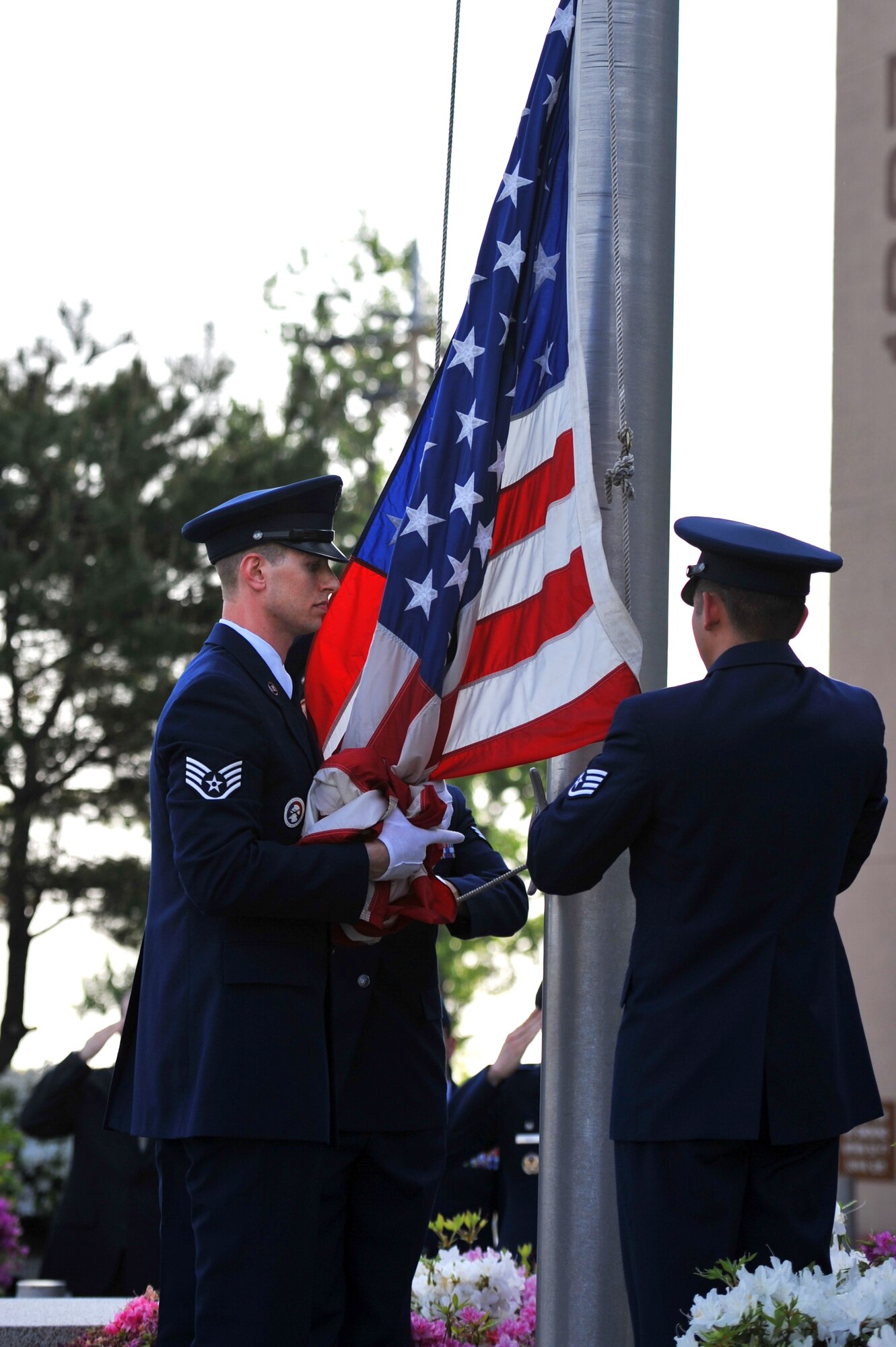 Osan Honor Guard members bring down the flag during a retreat ceremony at Osan Air Base, Republic of Korea, May 13, 2013. The ceremony kicked off an annual week-long observance that highlights some of the skills and capabilities of the 51st Security Forces and Office of Special Investigations units here. (U.S. Air Force photo/Staff Sgt. Emerson Nuñez)