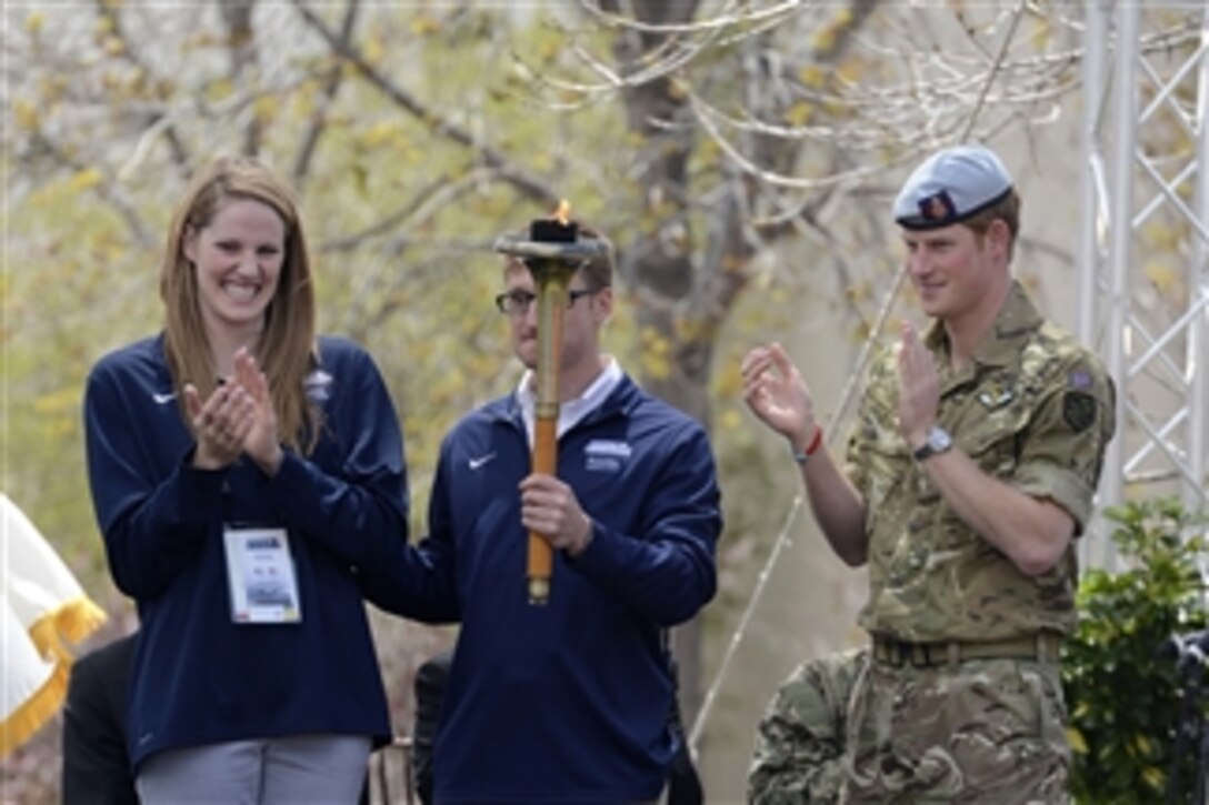 U.S. Olympic swimmer Missy Franklin, left, Paralympian gold medal winner Navy Lt. Bradley Snyder, center, and Prince Harry prepare to light the official torch to begin the 2013 Warrior Games at the U.S. Olympic Training Center in Colorado Springs, Colo., on May 11, 2013.  More than 200 wounded, ill, and injured service members and veterans from the Army, Navy, Air Force, and Marines as well as a team representing U.S. Special Operations Command and an international team representing the United Kingdom, will compete for the gold in track and field, shooting, swimming, cycling, archery, wheelchair basketball and sitting volleyball at the training center and U.S. Air Force Academy.  