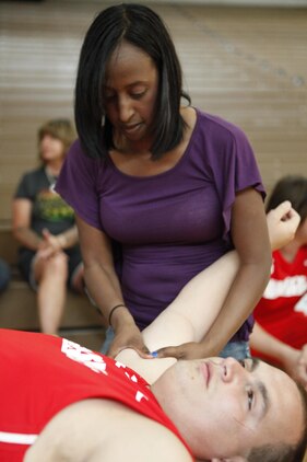Jeanette Falu-Bishop, the founder and executive director of Structure for Wounded Warriors, assists Zach Blair, Marine Corps team member, before wheel chair basketball at the 2013 Warrior Games in Colorado Springs, Colo., May 12. Falu-Bishop has provided body work to veterans and their families for nearly a decade.