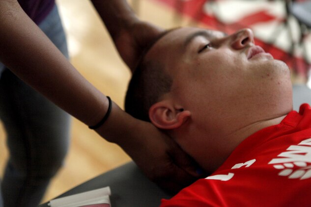 Zach Blair, Marine Corps team member, get a message before the wheel chair basketball  game at the 2013 Warrior Games in Colorado Springs, Colo., May 12. Jeanette Falu-Bishop, the founder and executive director of Structure for Wounded Warriors, has offered body work to all commpetitors at the Games.