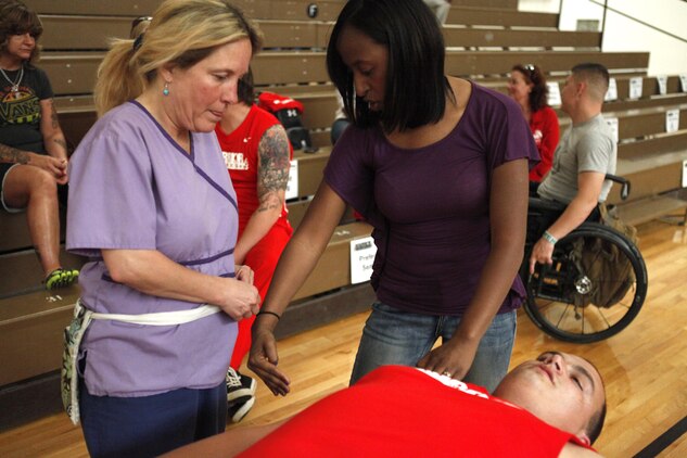 Jeanette Falu-Bishop, the founder and executive director of Structure for Wounded Warriors, educates her associate before wheel chair basketball at the 2013 Warrior Games in Colorado Springs, Colo., May 12. Falu-Bishop has provided body work to veterans and their families for nearly a decade.