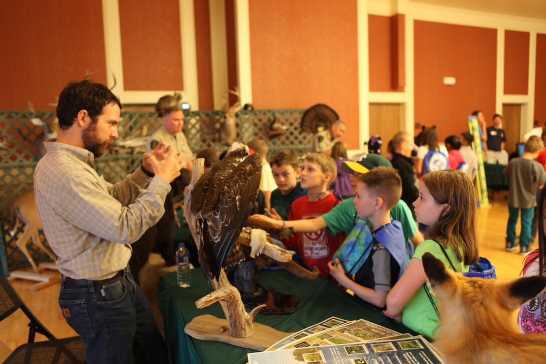 John DeLuca, a wildlife biologist aboard Marine Corps Base Camp Lejeune, explains how Ospreys feed with their talons during the 10th Annual Earth Day Fair and Art Contest at the Marston Pavilion aboard Marine Corps Base Camp Lejeune April 24. DeLuca also taught their eating habits. (Photo by Pfc. Justin A. Rodriguez/released)