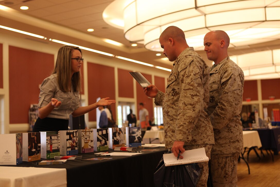 Lance Cpl. Joseph Robbins and Lance Cpl. Aaron Hardy, Marines with the 8th Communications General Support Battalion, read a college pamphlet during the National Education and Job Fair at the Marston Pavilion aboard Marine Corps Base Camp Lejeune April 18. The fair opened its doors to retirees, families, Camp Lejeune and Marine Corps Air Station Department of Defense employees, and Coastal Carolina college students. (Photo by Pfc. Justin A. Rodriguez/released)