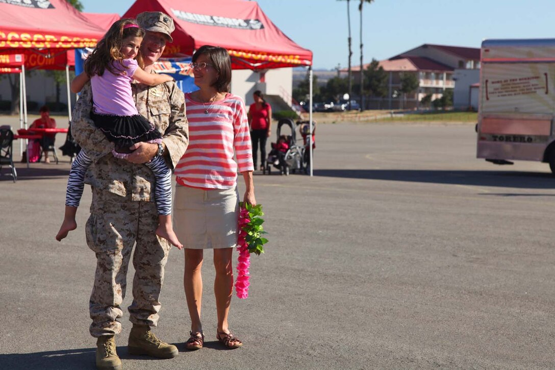 Lieutenant Cmdr. David D. Dinkins, chaplain, Command Element, 15th Marine Expeditionary Unit, reunites with his family after returning to Camp Pendleton, Calif., from an eight-month deployment aboard USS Peleliu, May 13. The 15th MEU, comprised of approximately 2,400 Marines and sailors, deployed on Sept. 17, 2012, as part of the Peleliu Amphibious Ready Group. Together with Amphibious Squadron Three, they provided a forward-deployed, flexible sea-based Marine Air Ground Task Force capable of conducting a wide variety of operations ranging from humanitarian aid to combat. (U.S. Marine Corps photo by Cpl. Timothy Childers / Released)