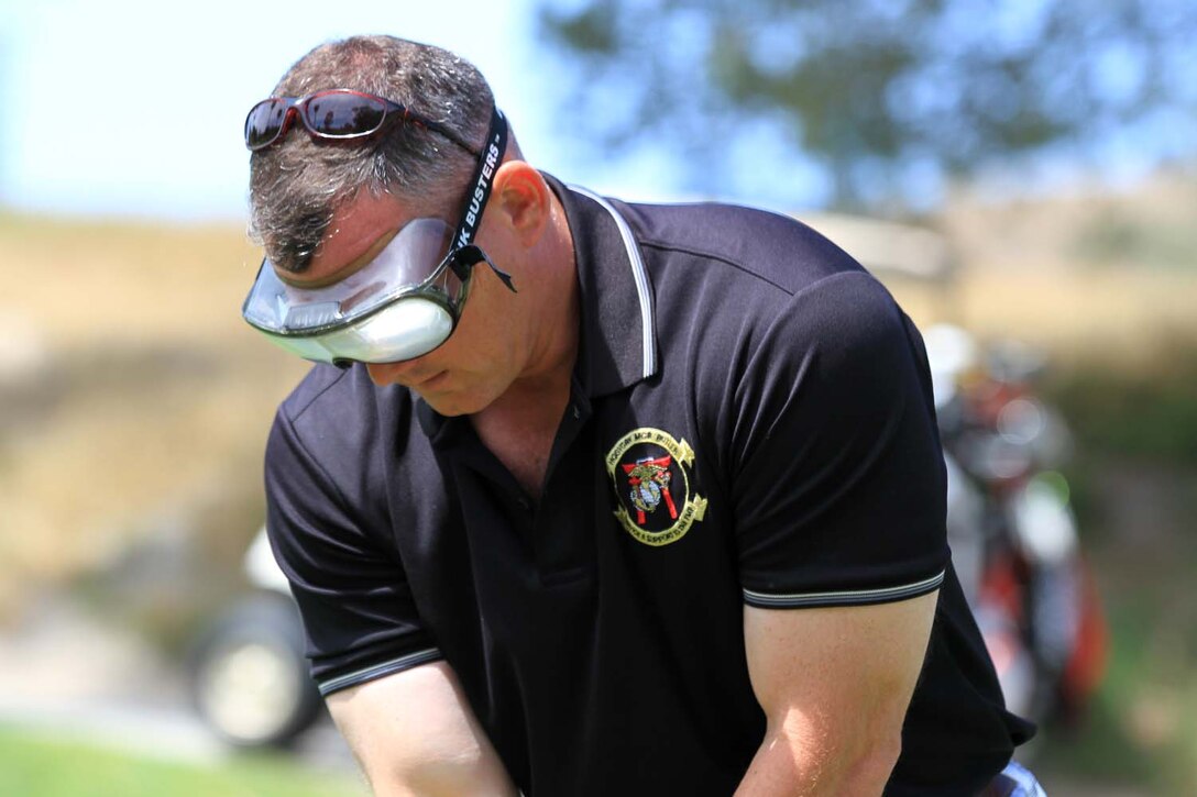Colonel Sean Sadler, the former commanding officer of Marine Aircraft Group 39, prepares to tee off with alcohol impairment goggles at the Commanding General's 2nd Invitational Golf Tournament at the Marine Memorial Golf Course here, May 14, 2013. The tournament provided a unique opportunity for Marines and sailors to network and share experiences with business and community leaders as well as golf industry experts. Each of the 18 holes on the course gave the participants challenges, varying from wearing a flak jacket to playing with alcohol impairment goggles. The intent of the invitational was to highlight facilities aboard the base that are accessible to civilians and provide information about the installation to invited guests.